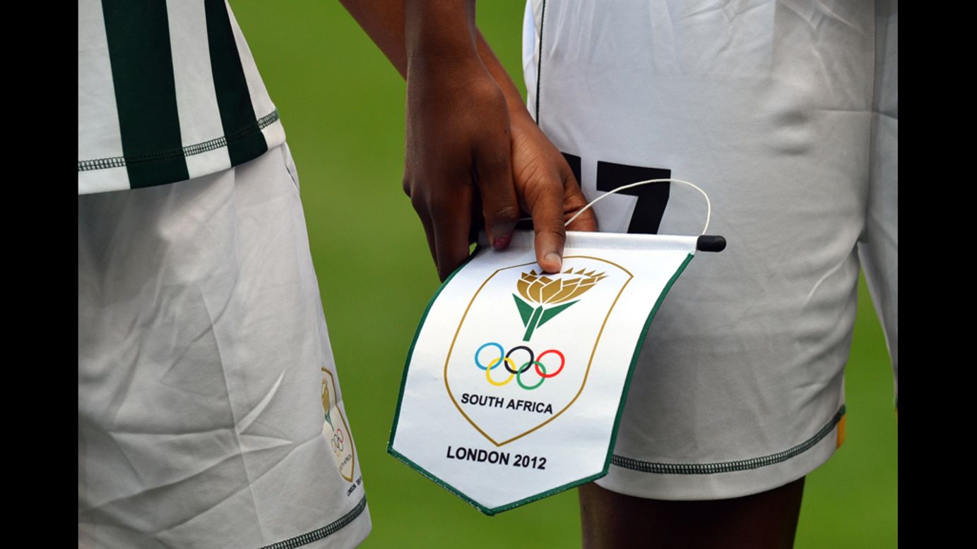 South African footballers hold a pennant as they line up before their first-round women's soccer match against Sweden on July 25 at The City of Coventry Stadium in Coventry, England.