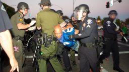 ANAHEIM, CA - JULY 24: A protester is taken into custody during a demonstration to show outrage for the fatal shooting of Manuel Angel Diaz, 25, at Anaheim City Hall on July 24, 2012 in Anaheim, California. Diaz was fatally shot on July 21 by an Anaheim police officer and has sparked days of protests by the angered community. (Photo by Jonathan Gibby/Getty Images)