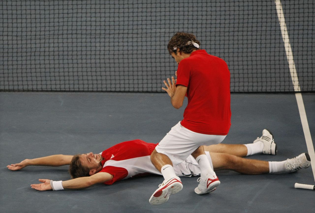 Wawrinka collapses after winning the match point in the final against Sweden's Simon Aspelin and Thomas Johansson.