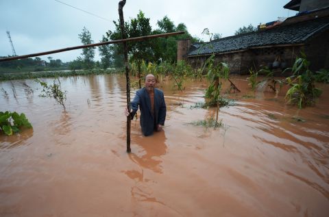 A farmer stands in his flooded field on the outskirts of Chongqing in southwest China on Sunday, July 22.