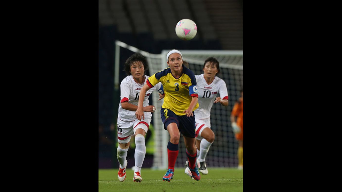 Hazleydi Rincon of Colombia and Kim Song Hui of North Korea chase the ball in a first-round women's football match.