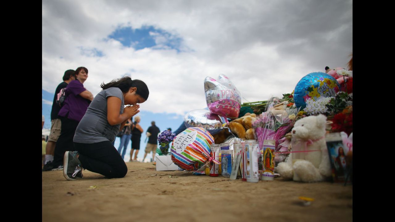 Yvonne Amaro, 9, prays for those injured and killed as she visits the memorial on Wednesday.