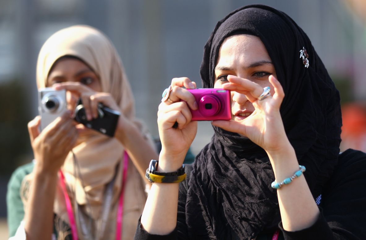 Spectators take pictures Thursday at the Olympic Village in London.