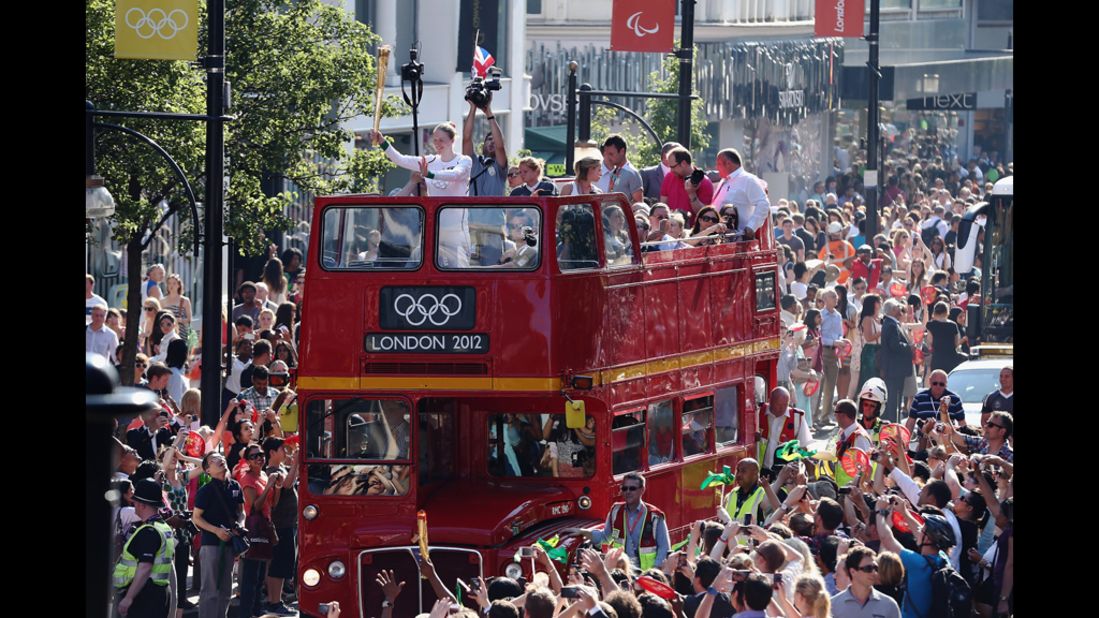 The Olympic torch is carried Thursday on top of an open top bus down Oxford Street in London.