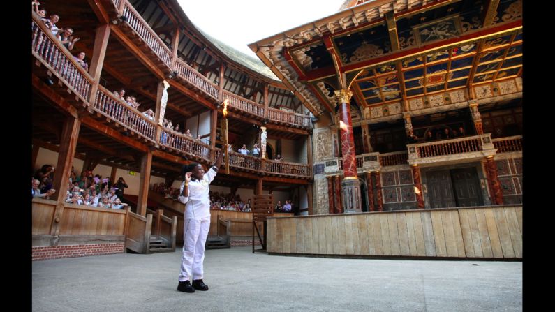 Torchbearer Ifeyinwa Egesi holds the Olympic flame inside the Globe Theatre in London on Thursday.