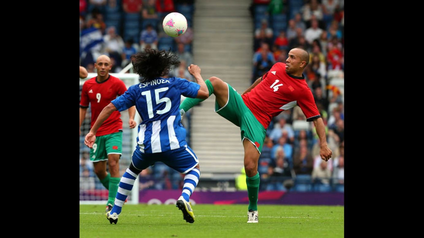Morocco's Houssine Kharja, right, controls the ball against Honduras' Roger Espinoza during a first-round Group D match Thursday in Glasgow, Scotland.