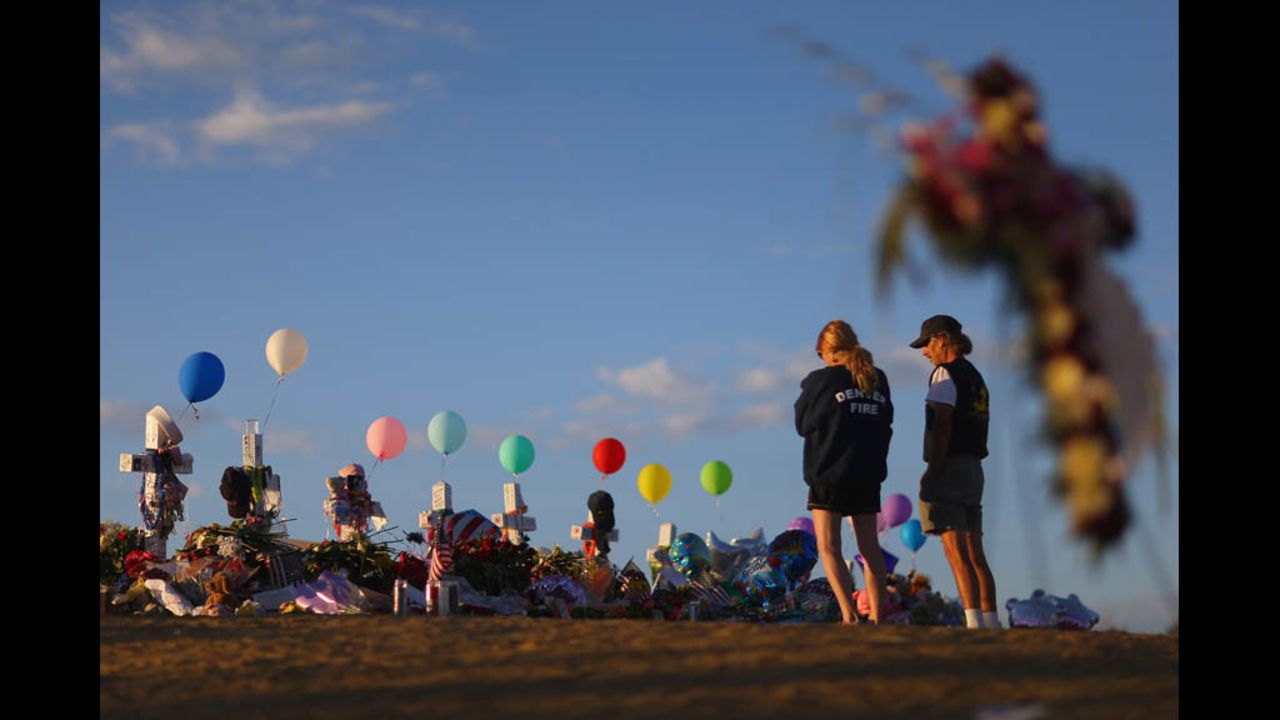 People visit a memorial across the street from the Century 16 movie theater on Thursday, July 26, in Aurora, Colorado.