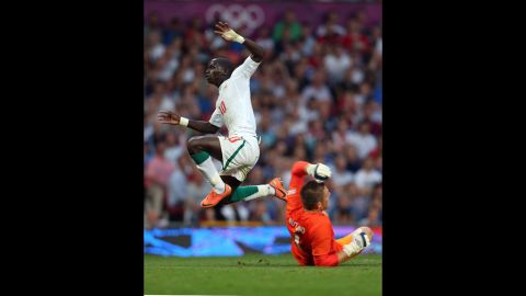 Sadio Mane of Senegal leaps over goalkeeper Jack Butland of Great Britain during the first-round men's soccer match between Great Britain and Senegal at Old Trafford on Thursday, July 26,  in Manchester, England.