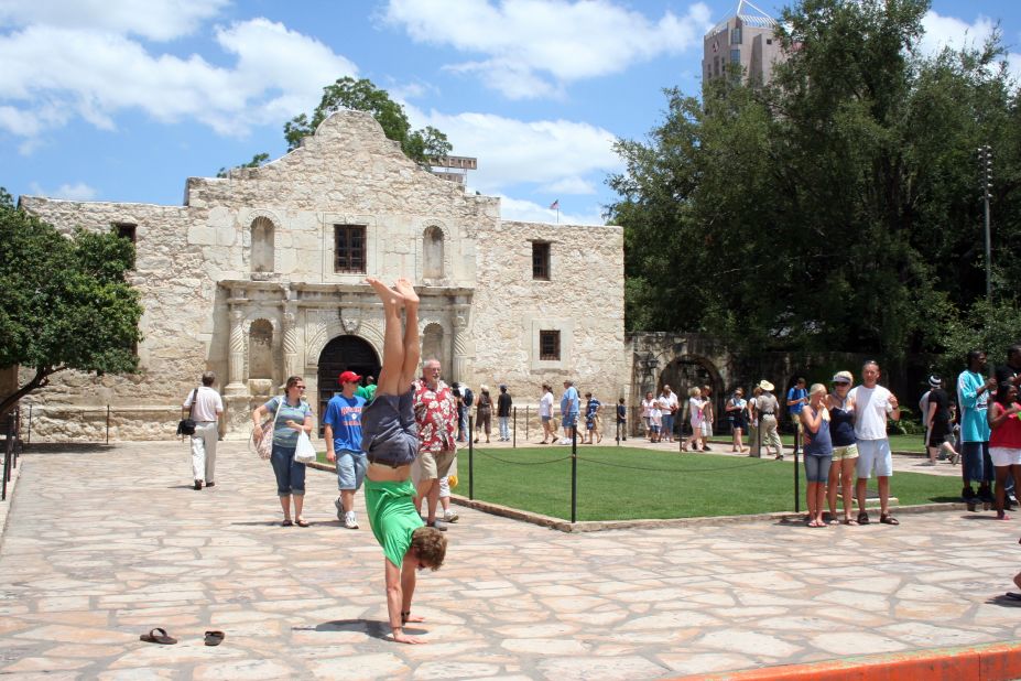 iReporter Andrew Bennett started doing handstands in front of landmarks while he was studying abroad in 2007. His handstand in front of The Alamo in 2008 draws some interest from other visitors