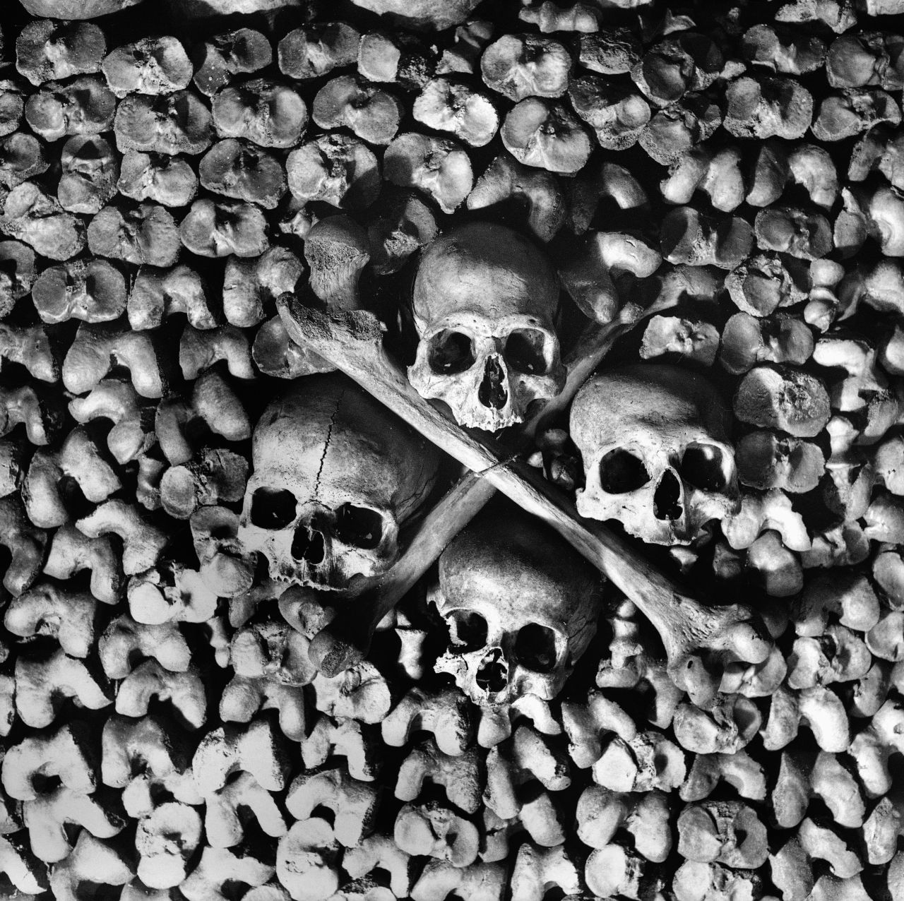 Skulls and bones are arranged to form the walls of the tunnels in the Paris Catacombs. Circa 1900.