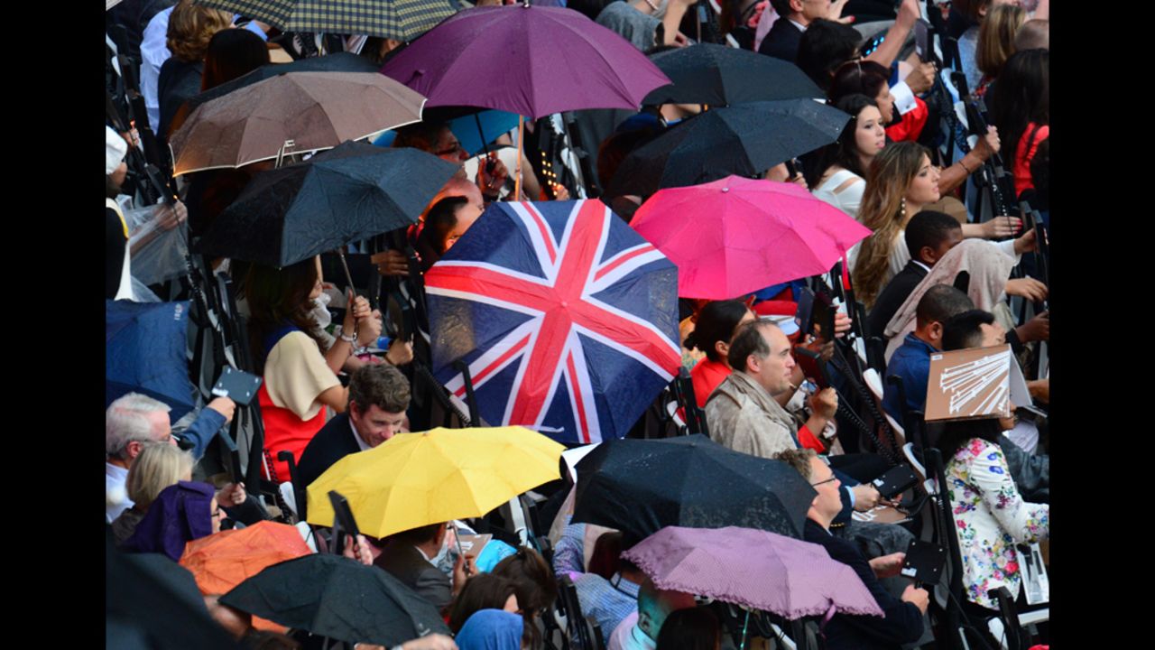 Spectators wait under the rain before the ceremony.