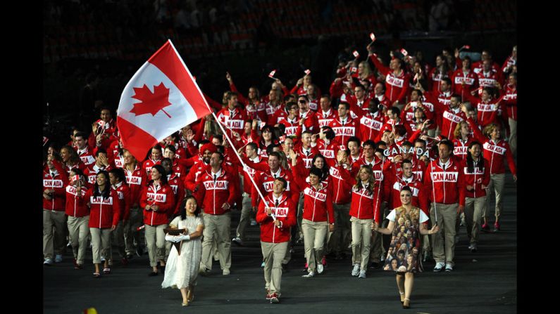 Simon Whitfield of the Canada Olympic triathlon team carries his country's flag.