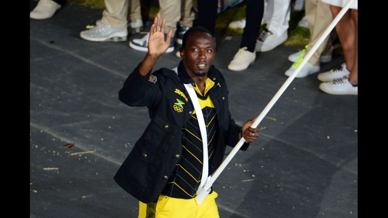 Reigning Olympic men's 100-meter and 200-meter champion Usain Bolt of Jamaica carries his country's flag.