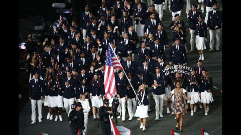 Mariel Zagunis of the United States Olympic fencing team carries her country's flag.