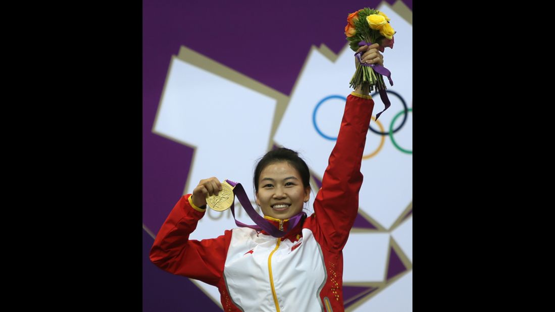 China's Yi Siling celebrates with her gold medal on the podium after winning the 10-meter air rifle women's final.