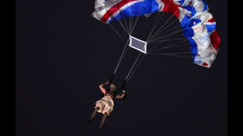 An actor dressed to resemble Britain's Queen Elizabeth II parachutes into the stadium during the opening ceremony.