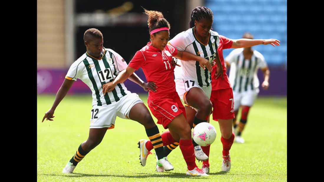 Desiree Scott of Canada and Andisiwe Mgcoyi of South Africa fight for the ball during a first-round women's soccer game.