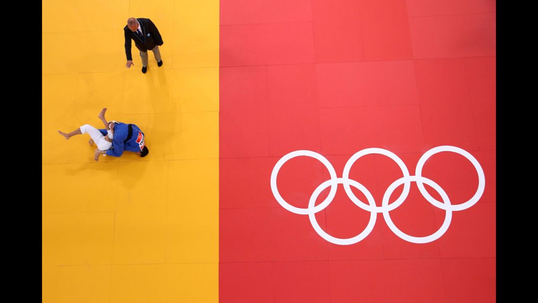 Sofiane Milous of France, in white, competes with Hovhannes Davtyan of Armenia during the men's judo event.