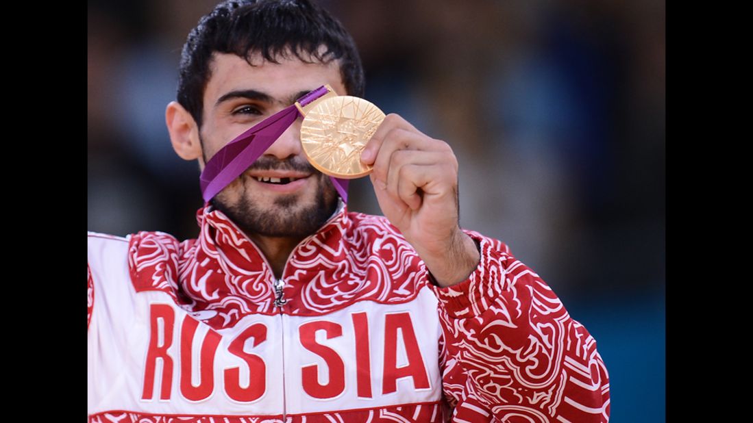 Russia's gold medalist Arsen Galstyan poses on the podium of a men's judo event.