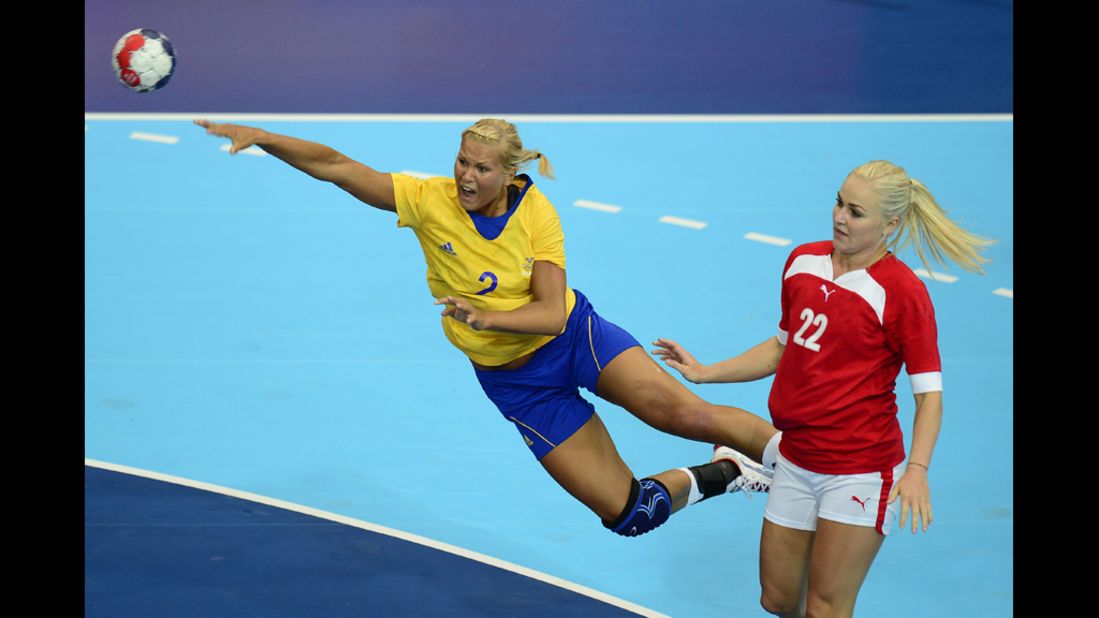 Sweden's pivot Ulrika Agren, left, shoots under the look of Denmark's leftback Trine Troelsen during a women's preliminary handball match.