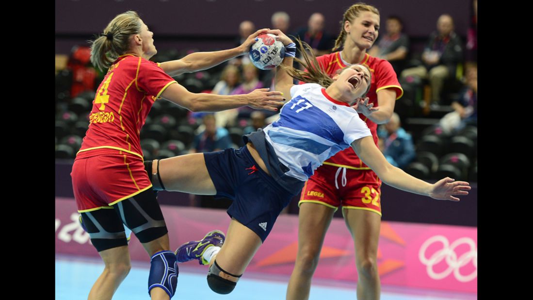 Britain's leftback Ewa Palies, center, vies with Montenegro's Maja Savic, left, and Katarina Bulatovic during a women's preliminary handball match.