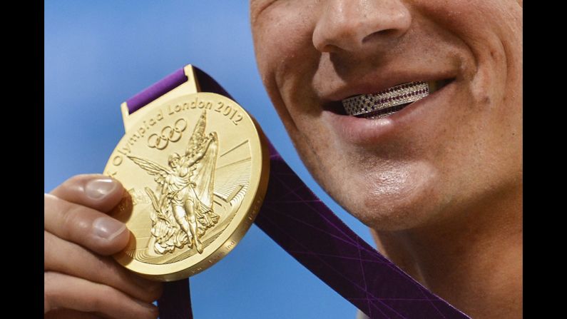 Lochte poses with medal on Saturday. His dental braces bear the U.S. flag.