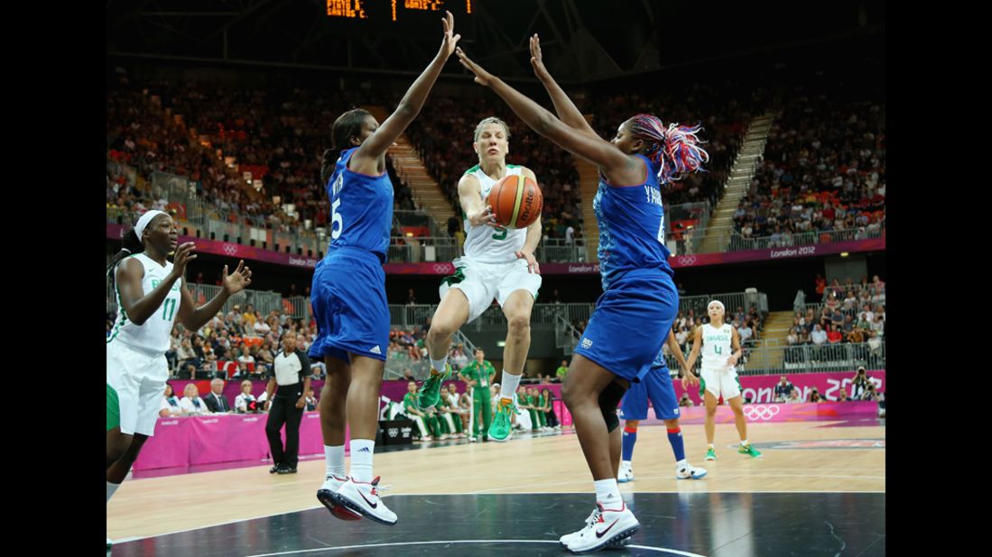 Brazil's Karla Costa, No. 5, looks to pass against France's Endene Miyem, No. 5, and Isabelle Yacoubou, No. 5, of France in the first half of the women's basketball competition.