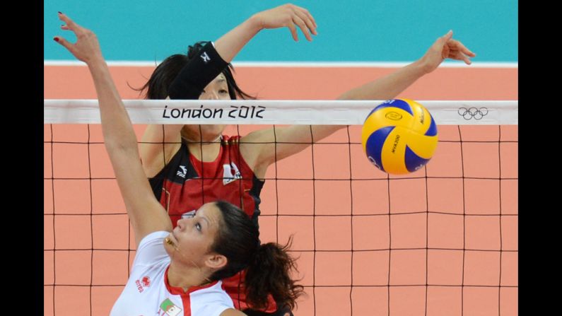 Algeria's Sehryne Hennaoui spikes the ball as Japan's Yukiko Ebata reaches to block during a women's volleyball match.
