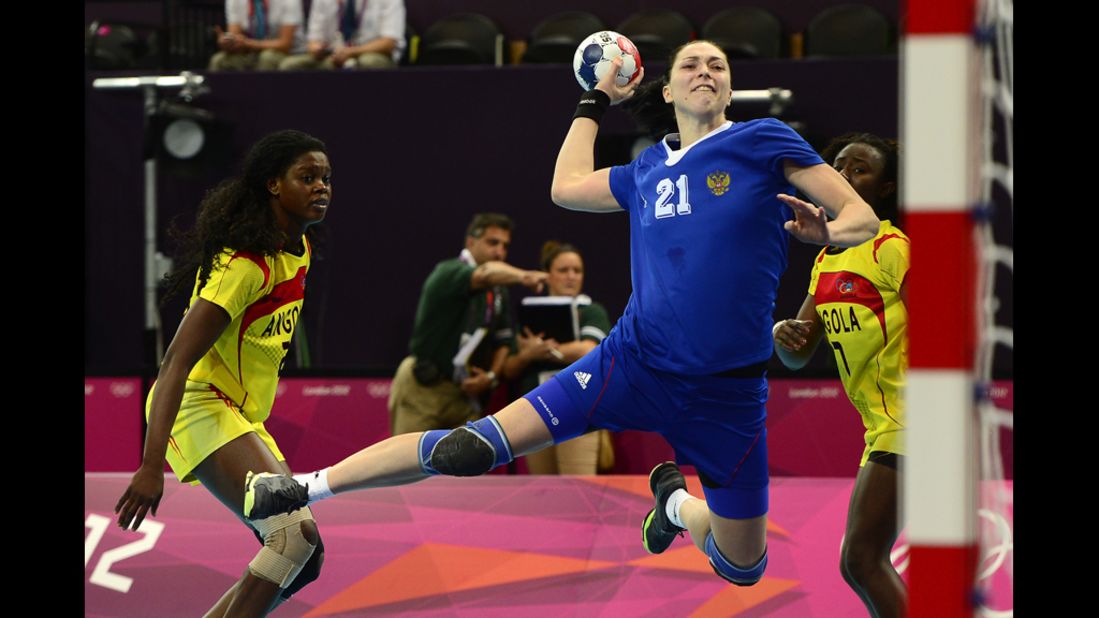 Russia's leftback Victoria Zhilinskayte, right, jumps to shoot during a preliminary round handball match against Angola.