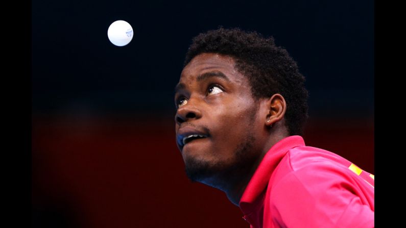 Mawussi Agbetoglo of Togo serves against Justin Han of Australia during their preliminary round singles match in the table tennis competition.