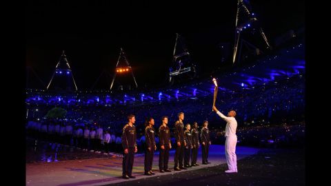 Torchbearer Sir Steve Redgrave hands the Olympic flame over to the seven young athletes who represent Britain's hopes for the next Olympics.