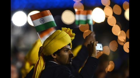A member of India's delegation takes a picture as he parades during the opening ceremony.