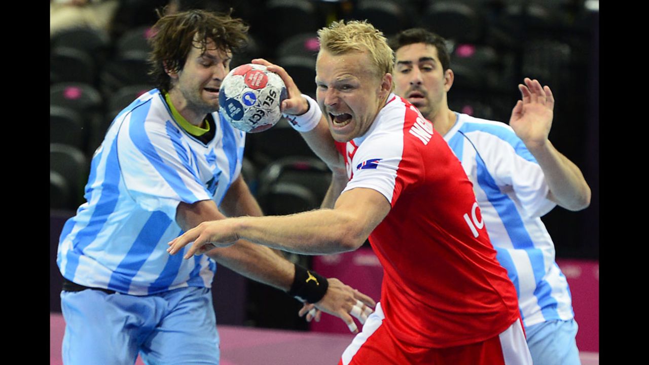 Gudjon Valur Sigurdsson of Iceland, center in red, prepares to shoot against Argentina during a men's preliminary handball match.