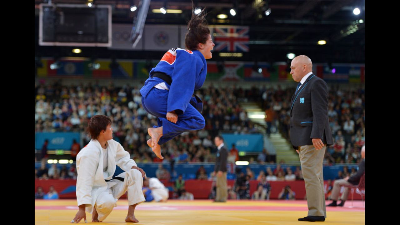 Romy Tarangul of Germany, center in blue, celebrates her win against Natalia Kuziutina of Russia in the women's 52 kilogram judo event.