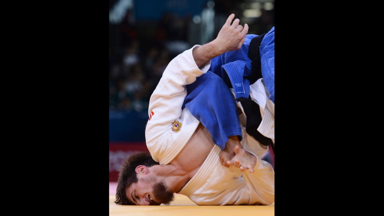 Musa Mogushkov of Russia, in white, competes with Azerbaijan's Tarlan Karimov, in blue, during their men's 66 kilogram judo event.