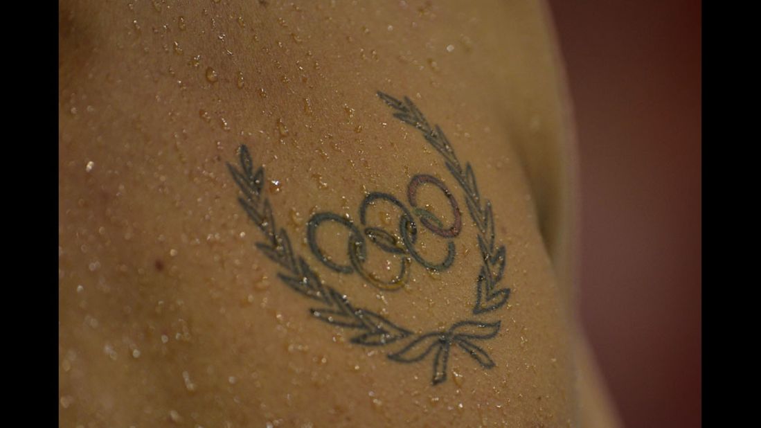 An athlete's Olympic rings tattoo is seen during a swimming event.
