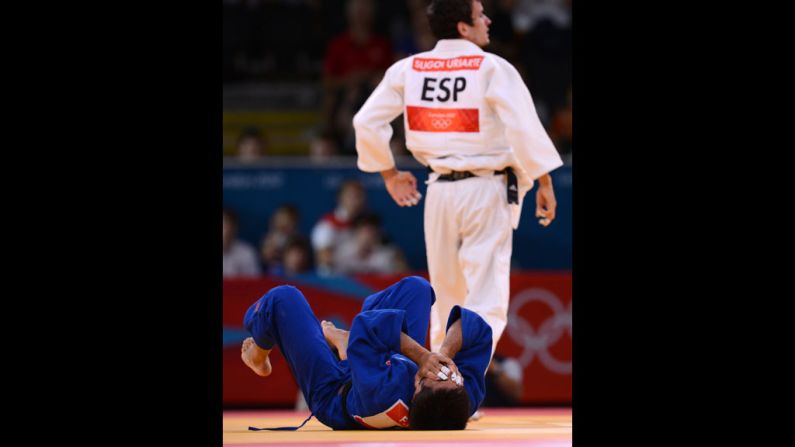 Francesco Faraldo of Italy, in blue, reacts after losing against Sugoi Uriarte of Spain, in white, during their men's judo event.