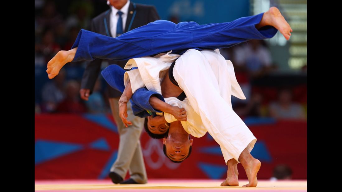 Masashi Ebinuma of Japan, in white, competes against Sergey Lim of Kazakhstan in a men's under 66-kilogram judo bout.