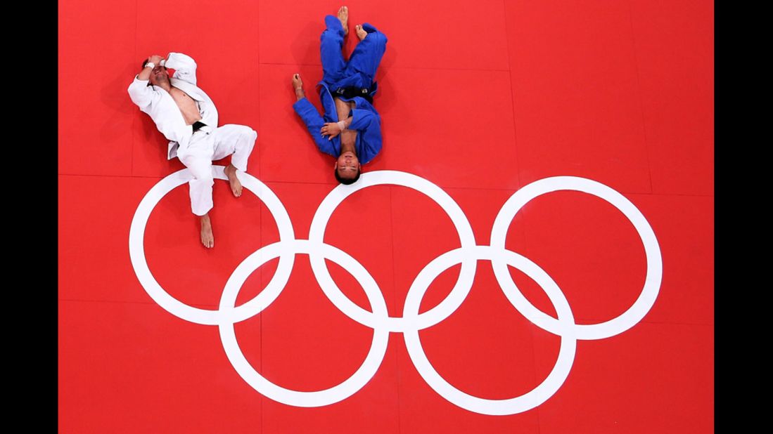 Poland's Pawel Zagrodnik, left, and Masashi Ebinuma of Japan rest on the mat after their men's under 66-kilogram judo match.
