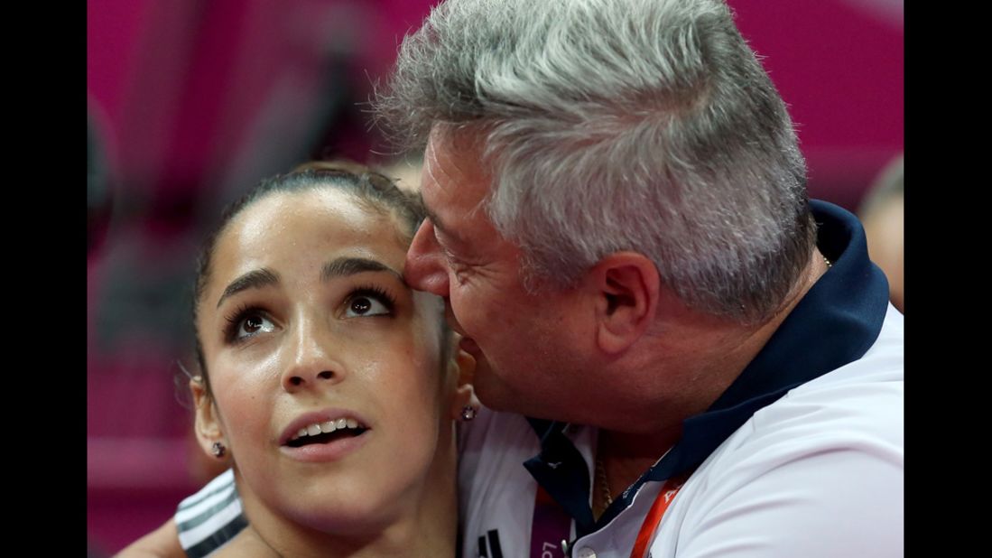 American Alexandra Raisman hugs coach Mihai Brestyan during the artistic gymnastics women's team qualification round.
