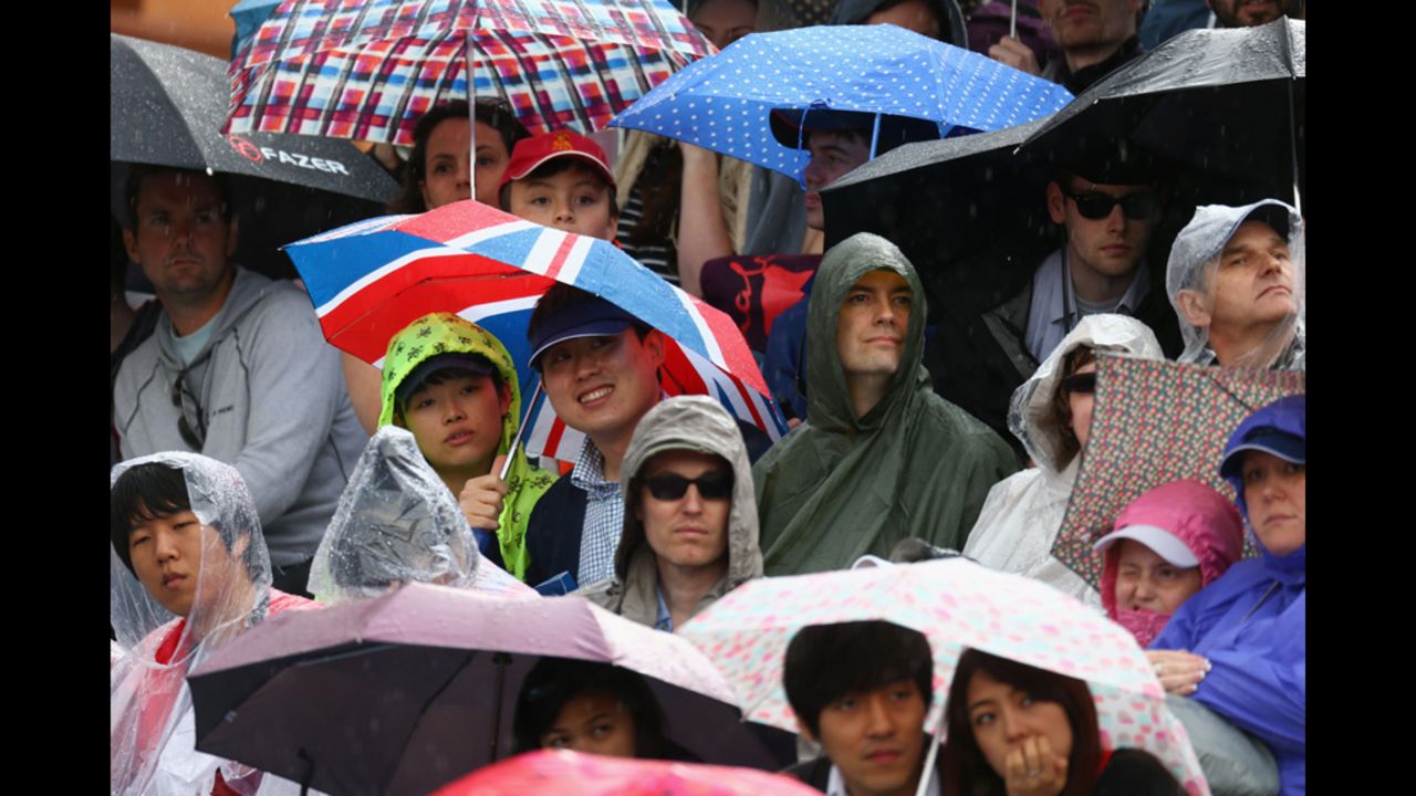 Fan shield themselves from the rain during the women's team archery event at Lord's Cricket Ground in London.