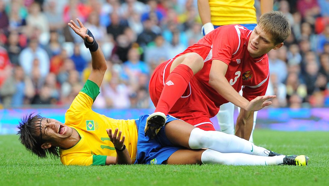 Neymar, left, of Brazil reacts during the men's football match with Belarus' Igor Kuzmenok in Manchester, England.