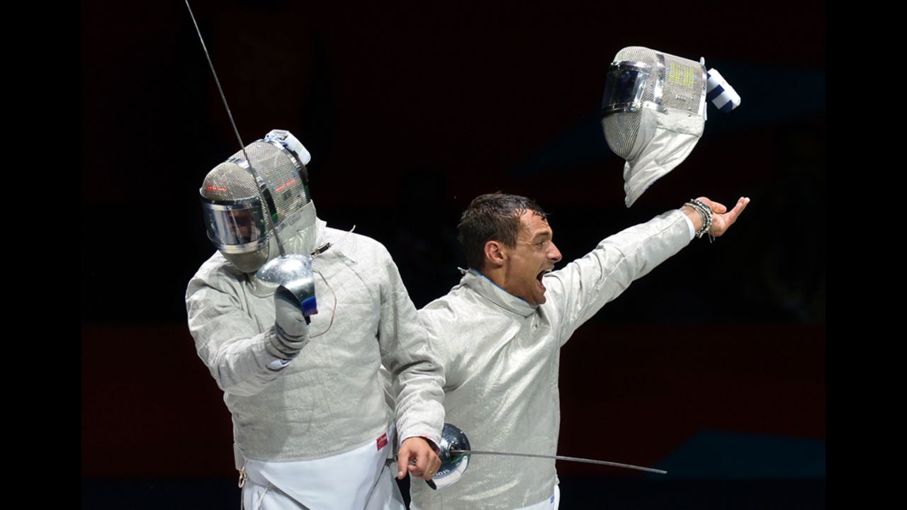 Italy's Diego Occhiuzzi, right, celebrates his victory over Romania's Rares Dumitrescu during the men's saber semifinal fencing bout.