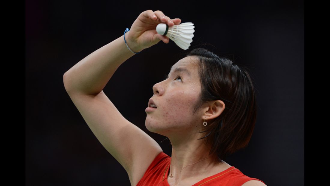 Japan's Sayaka Sato reads the directions on the shuttlecock before a serve.