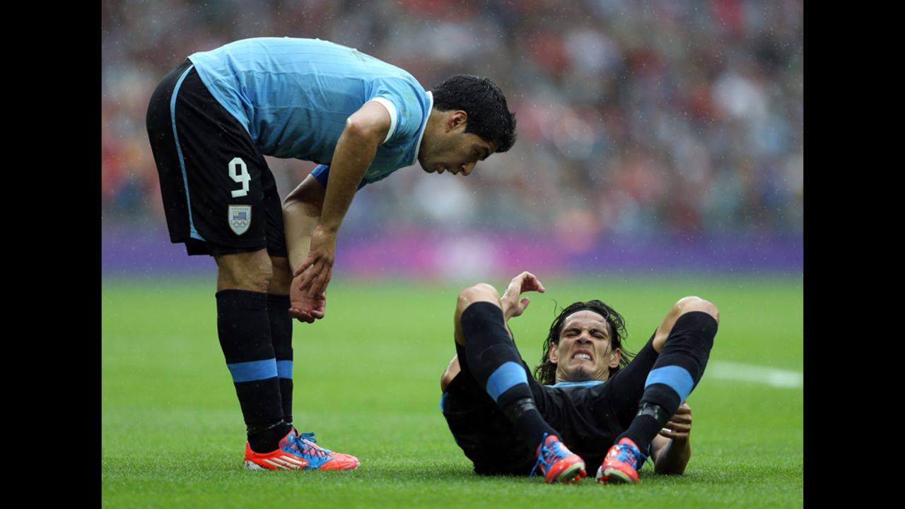 Edinson Cavani of Uruguay attempts to set a world sit-up record. A teammate counts off beside hm.