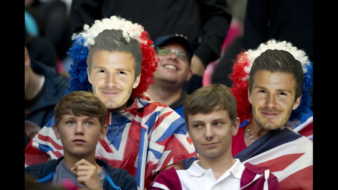 Football fans wear masks depicting David Beckham while waiting for the match between United Arab Emirates and Great Britain to begin at Wembley Stadium.