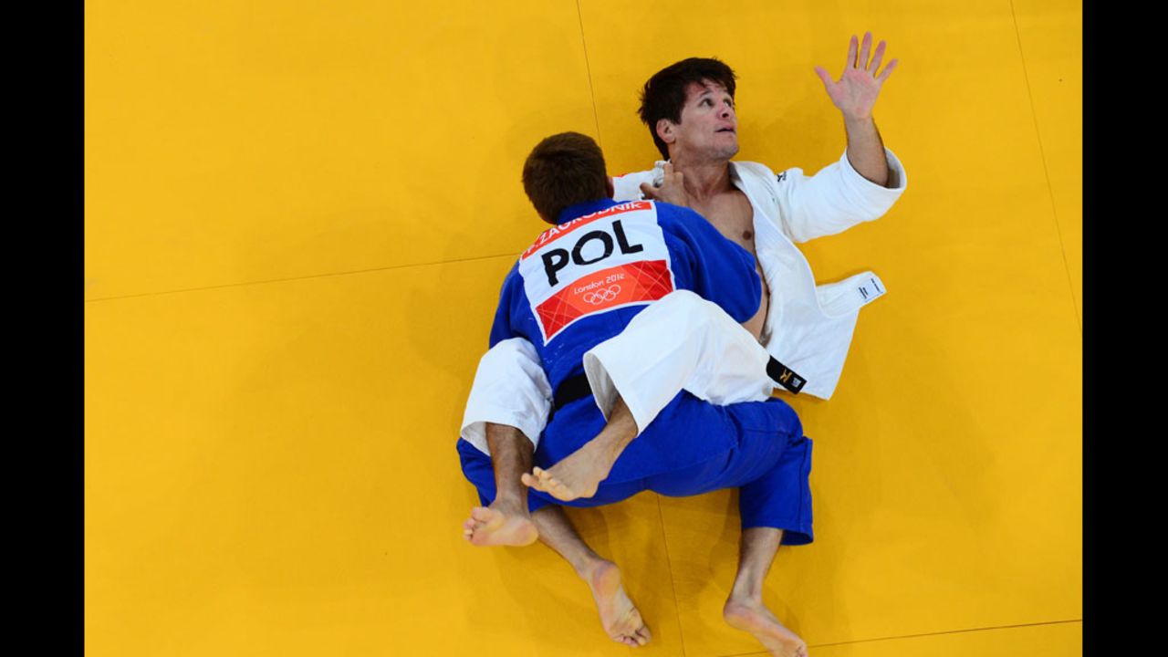 Leandro Cunha of Brazil, in white, competes with Pawel Zagrodnik of Poland, in blue, during their men's 66 kilogram judo event.