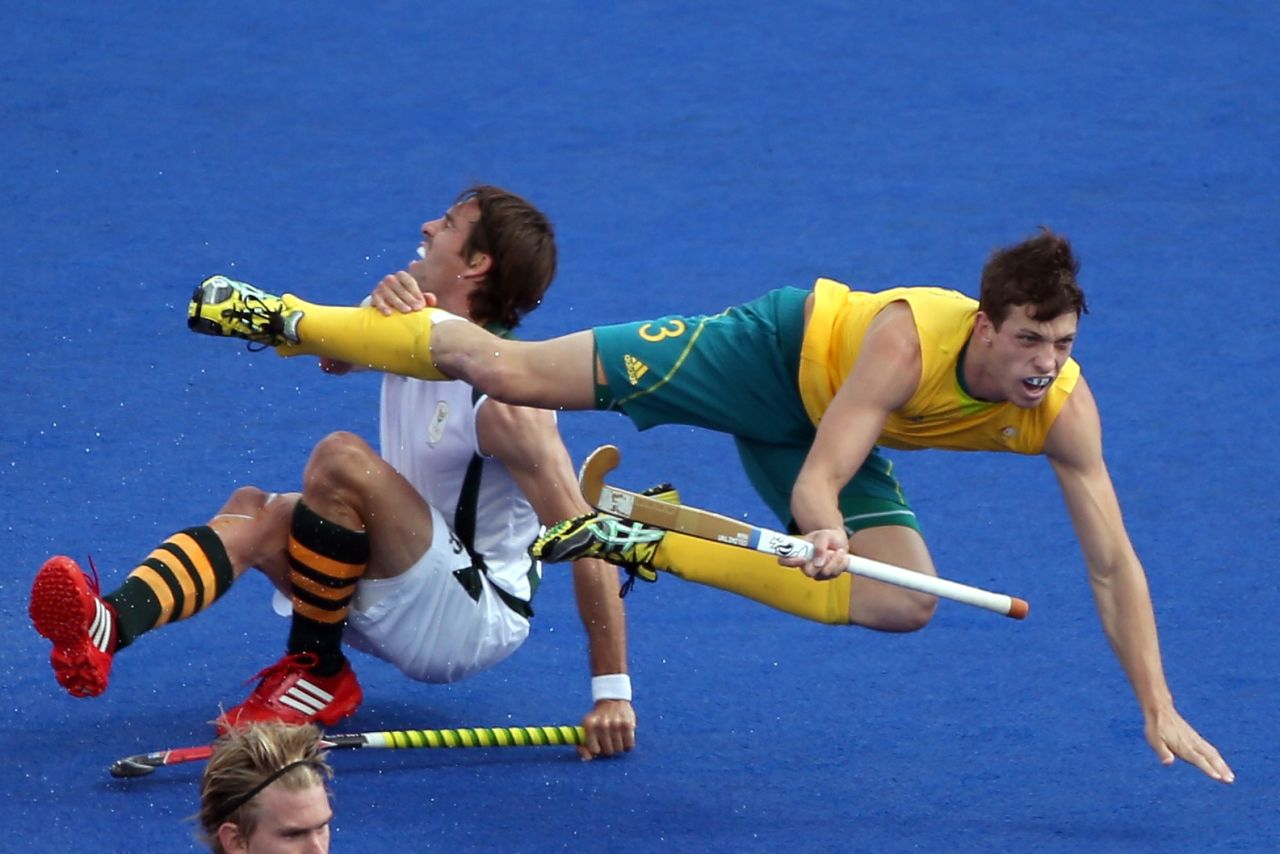 Simon Orchard of Australia fights for the ball against Thorton McDade of South Africa during the men's field hockey match Monday.