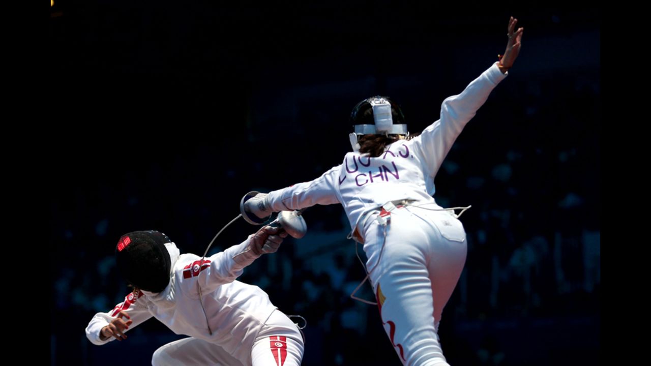 Sarra Besbes of Tunisia, left, tries for a point against Xiaojuan Luo of China during their women's epee fencing round Monday.
