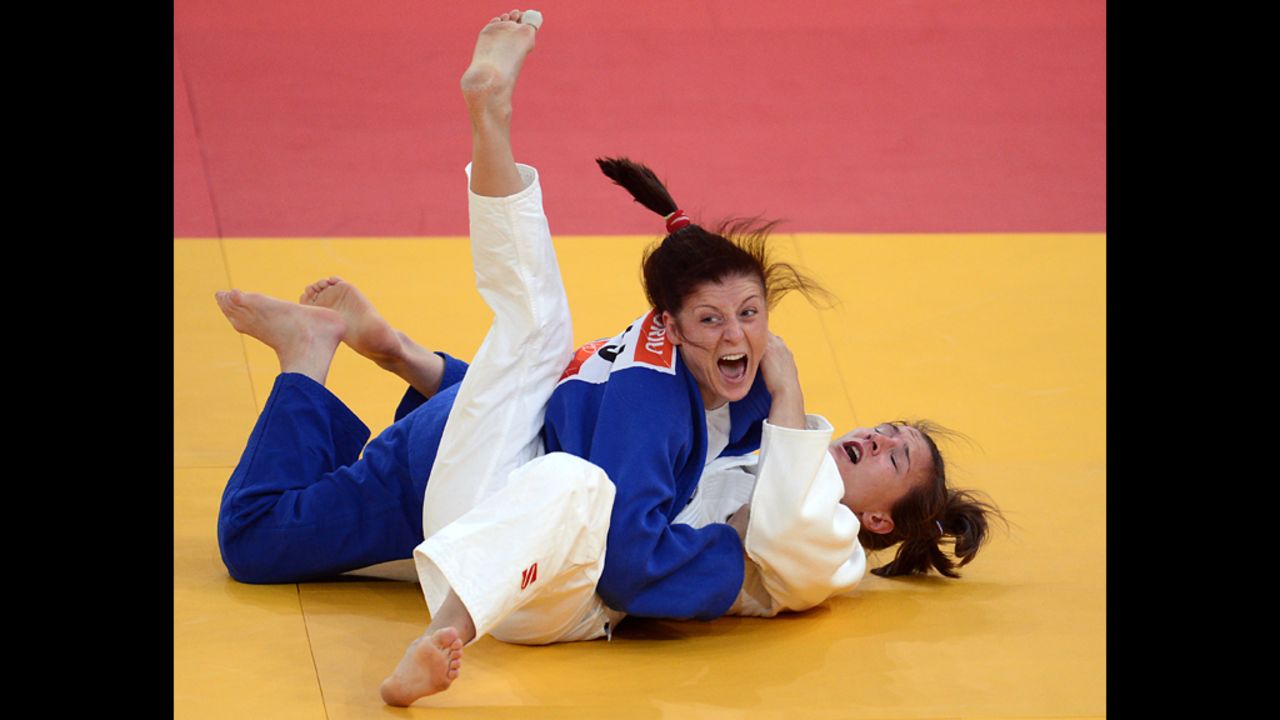 Romania's Corina Caprioriu, in blue, celebrates after defeating Marti Malloy of the United States during the women's 57-kilogram judo contest semi-final match Monday.